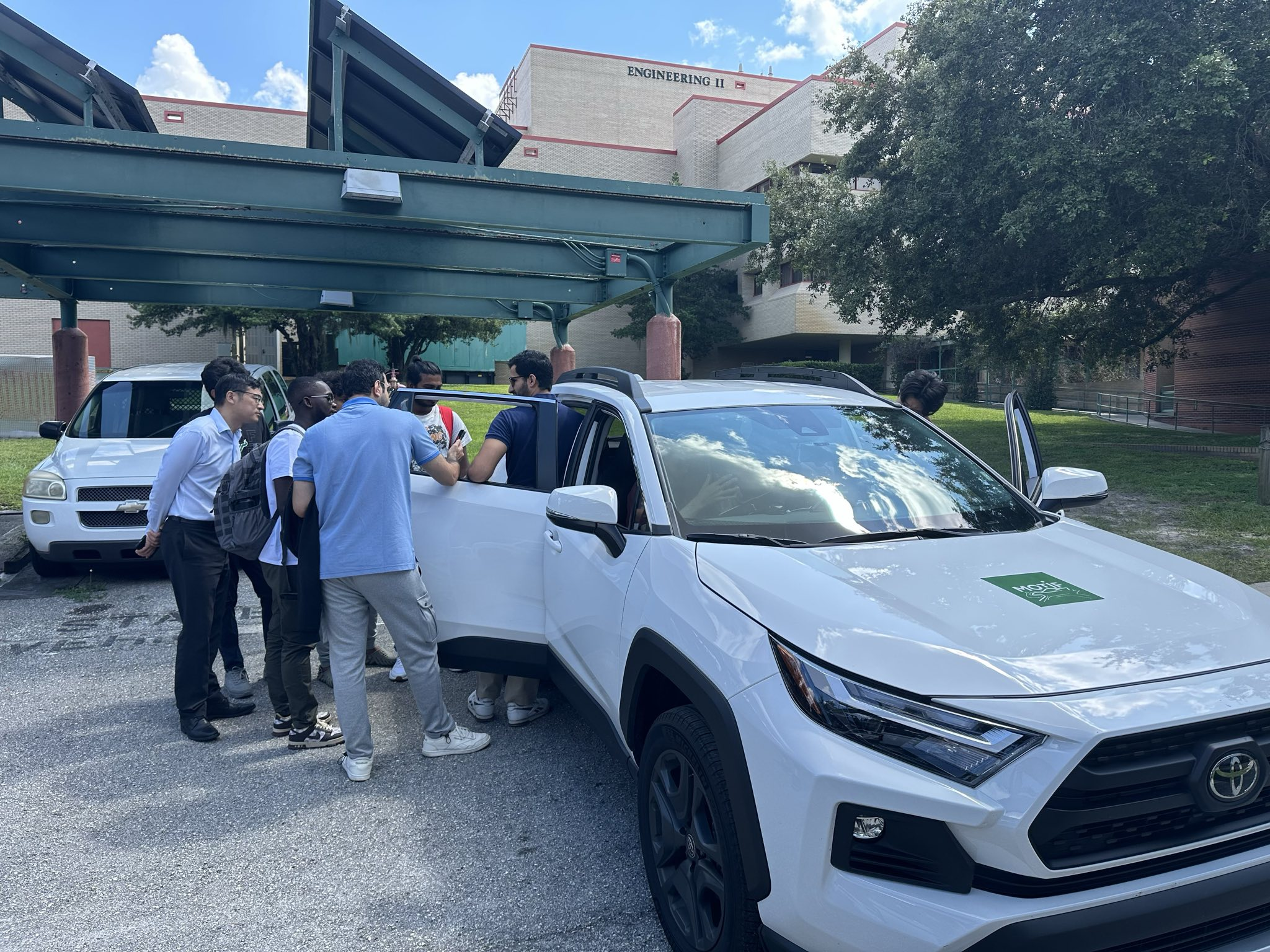 MOTIF lab Toyota RAV4 parked under a USF solar canopy with students